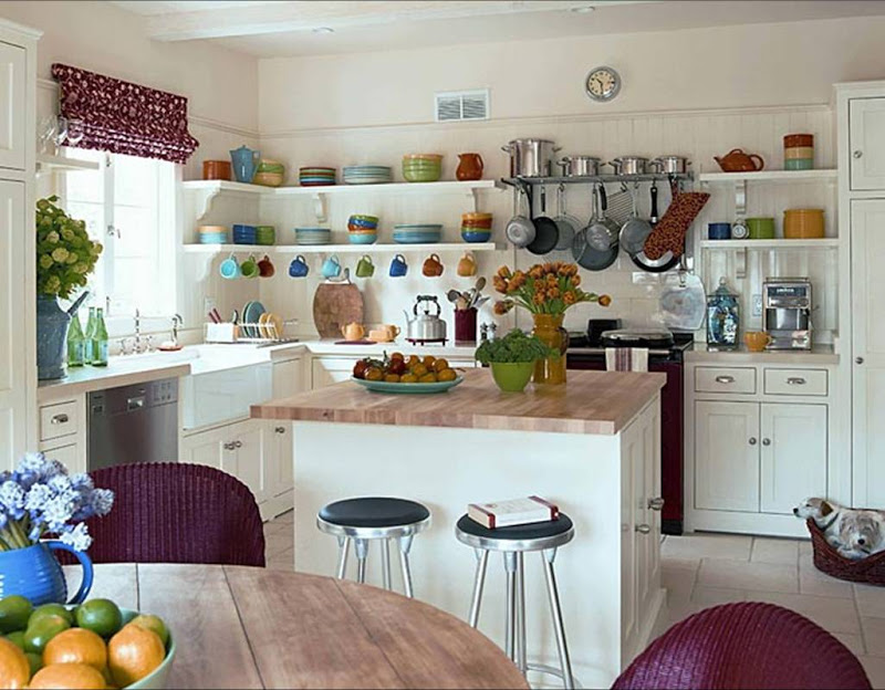 Kitchen with butcher block countertops, open shelving, white cabinets and purple Roman shades and wicker dining chairs
