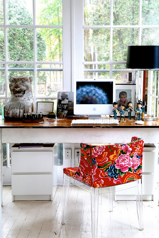 Home office by Robert and Cortney Novogratz with a lucite Mademoiselle Kartell chair with Missoni fabric in front of a picture window