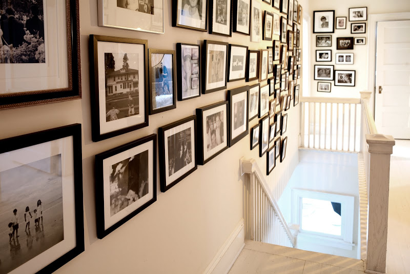 Stairwell lined with black and white photos and prints in Robert and Cortney Novogratz's home