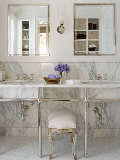 White Carrara marble slab used to cover wall and as backsplash in a city apartment's bathroom