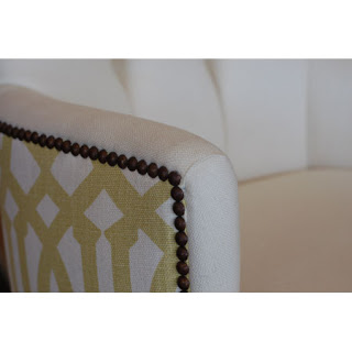 Close up of a tufted dining room chair with nail head trim and a pattered upholstered back from Plush Home
