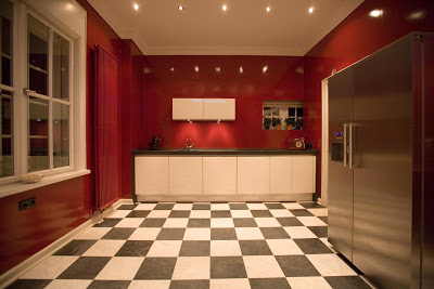 Kitchen in a Hamburg home with bright red walls and black and white checkerboard floor