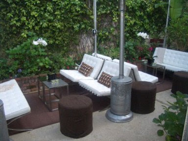 Outdoor patio with white Barcelona inspired chairs and sofa, orchids and metal side tables