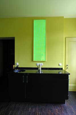 Kitchen with black counters, yellow walls and modern kitchen light