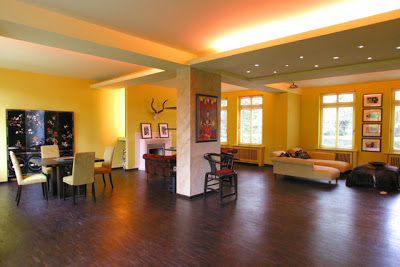 Living and dining room with yellow walls and dark wood floor