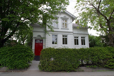 Exterior of a white Hamburg home with a red door