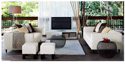 Outdoor patio with white dueling sofas, two white square ottomans, a TV and two round link side tables from cb2