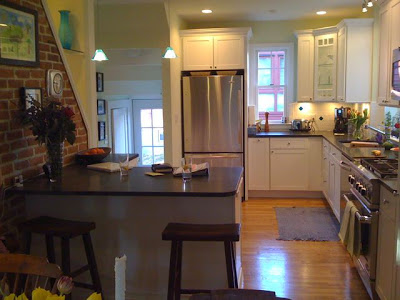 Kitchen after remodeling with white shaker style cabinets, stainless appliances and granite counter tops