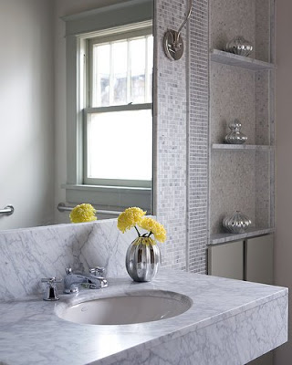 Bathroom with grey marble counter tops, undermount sink, grey marble mosaic tiles and metal fixtures and accessories
