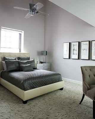Grey bedroom with upholstered bed, textured grey carpet and tale lamp with clear base and silver grey metal shade