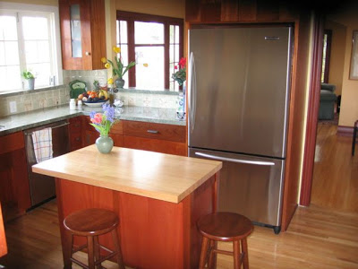 Kitchen after remodeling with mahogany cabinets, an island and stainless appliances