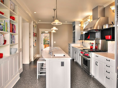 Kitchen with marble counter tops and backsplash, undermount sink, stainless steel appliances, built in shelving and frosted glass pendant lights