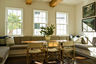 Dining room and breakfast nook with exposed beams and built in banquette seating around a simple wood table