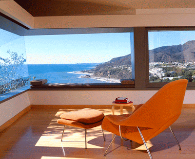 Saarinen womb chair and ottoman in a sitting room with an amazing picture view and a view of the ocean