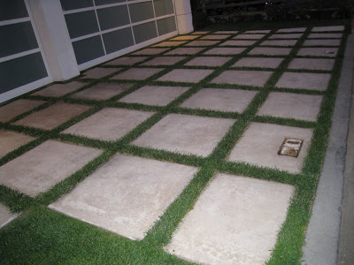 Rectangle shaped cement paving stones surrounded by grass