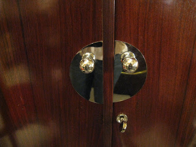 Close up of an art deco armoire with polished chrome knobs and plates
