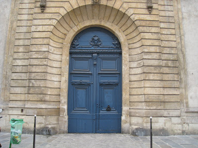 A very grand and regal looking door featuring a carved arch at top in Place Vendome