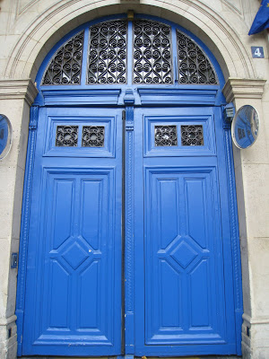 Royal blue double door in Paris with iron scrollwork