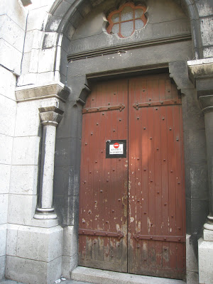 An ancient looking wood door next to the church crypt at Sacre Coeur