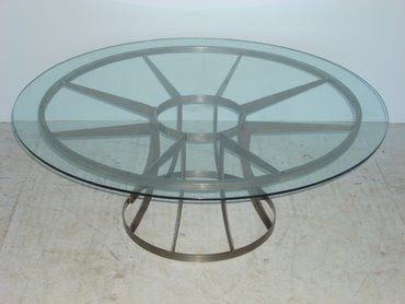 Round glass top coffee table with metal spoke base from Mecox Gardens