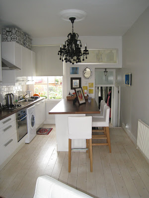 Small London kitchen with an island that seats four at the counter and white upholstered bar stools