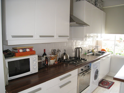 London kitchen with white tile backsplash and stainless appliances
