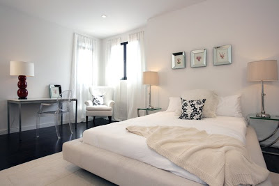 White bedroom with a Philippe Starck Louis Ghost Chair at a metal desk