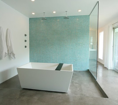 Master bathroom suite gets grey concrete floors, a freestanding tub, two rain shower and a clear frameless glass shower screen and a wall of turquoise blue tile after the remodeling by The Sunset Team/La Kaza Design