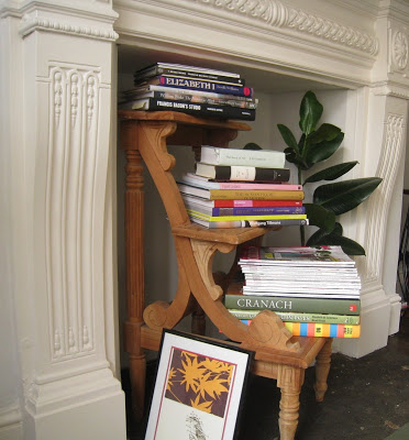 Wooden step stool converted into a miniature bookshelf in a fireplace mantel in a London flat