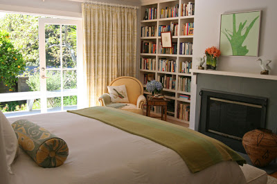 Bedroom with built in bookcases next to a fireplace
