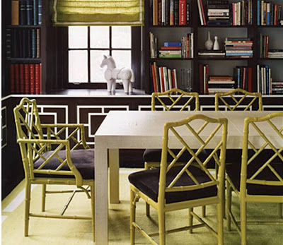 Dinning room with built in bookcases full of books, decorative molding on the cabinets and chartreuse Chippendale chairs