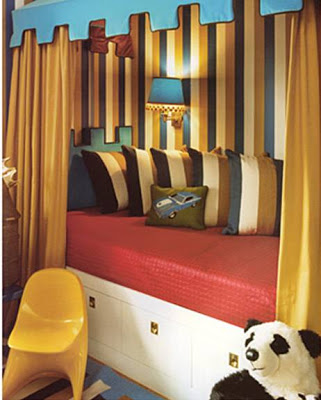Castle themed kid's bedroom with gold, blue and white striped walls and royal beds spread