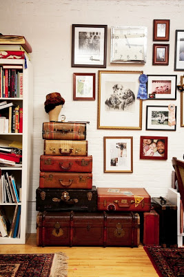 Stack of leather suitcases and a blue glass chandelier in an NYC apartment featured on The Selby