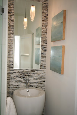 Bathroom with Ann Sacks glass mosaic tiles on the wall and a white modern sink and facuet