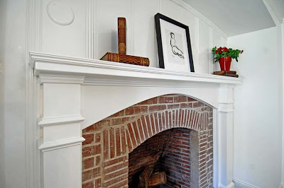 Master bedroom after remodeling by Newman & Wolen Design with refurbished fireplace inglenook and brick fireplace