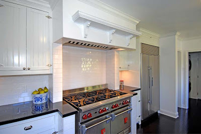 Kitchen after remodeling by Newman & Wolen Design with white subway tile backsplash, stainless steel appliances and a hood with decorative trim and molding