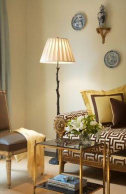 Living room with a settee upholstered in Greek key patterned fabric and yellow throw pillows with brown trim by Palmer Weiss