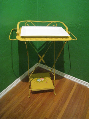 Bright yellow tray table in the corner of a Kelly Green dining room