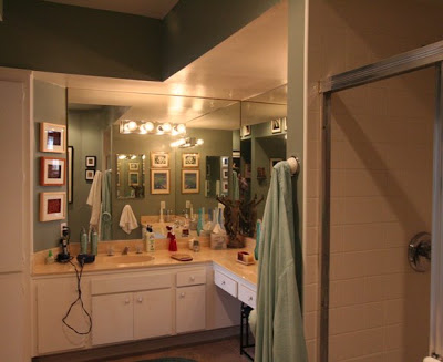 Bathroom vanity with outdated mirrors, vanity lights and cabinets prior to The Sunset Team's La Kaza Design's makeover