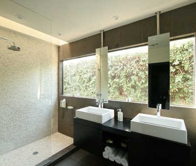 Modern bathroom after The Sunset Team/La Kaza Design's remodeling with large picture window, dark vanity and a shower tiled with pebble mosaic tiles