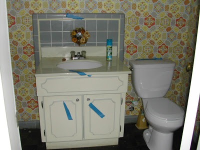 Powder room before remodeling by Newman & Wolen Design with yellow and grey wallpaper