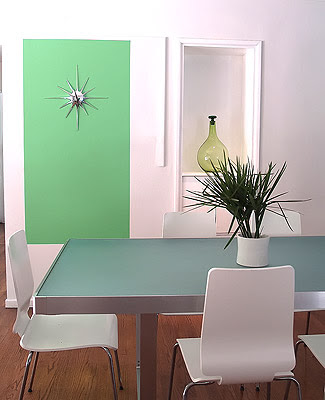 Close up of the green block with a sunburst wall decor painted on a white wall in a modern dining room designed by Vanessa de Vargas