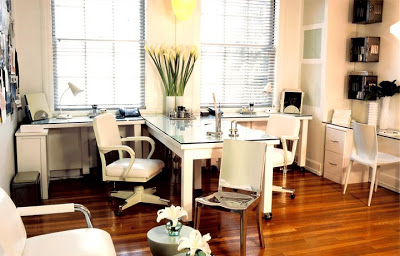 White home office by Jeff Andrews with white glass top desk, classic metal office chairs on wheels, white lower file cabinets with a Philippe Starck Hudson accent chair