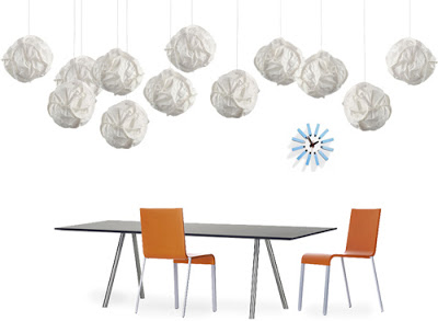 Cloud pendant lights design by Frank Gehry over a long modern table