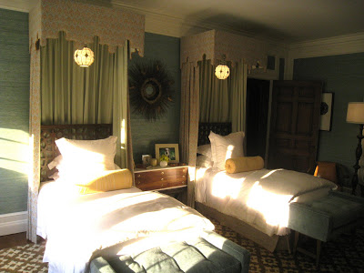 Guest bedroom in the Greystone Mansion with twin canopy beds draping being the head boards and yellow bolster cushions
