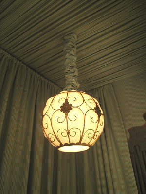Round and iron pendant lights hang from each canopy in a guest bedroom in the Greystone Mansion