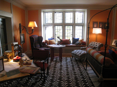 Gentleman's bedroom in the Greystone Mansion with bright orange walls and patterned rugs by James Lumsden 
