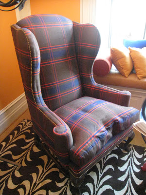 Plaid armchair on a bold patterned rug in a bedroom by James Lumsden in the Greystone Mansion