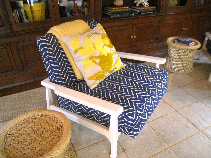White mid century armchair covered in blue and white fabric with bright yellow accent pillows in a sitting room designed by Lucas Studio, Inc in the Greystone Mansion