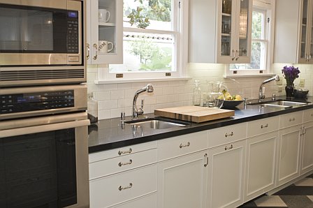 Kitchen after remodeling with two stainless steel undermount sinks, glass upper cabinets and refurbished windows